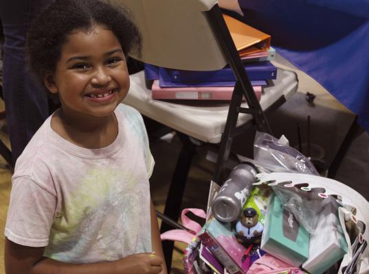 MAISIE ELLIE shows off her new backpack and school supplies.