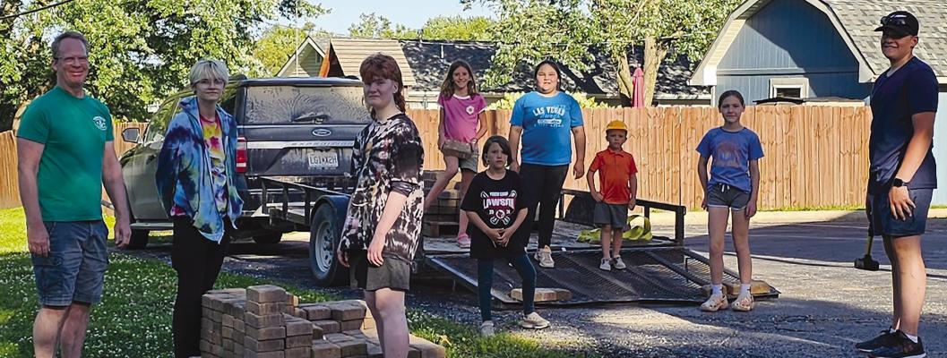 Members build patio with brick pavers around a fire pit. Submitted