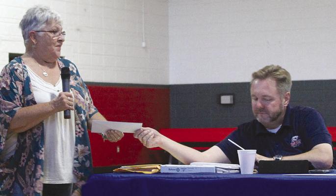NANCY COLEMAN (left) receives a Rotary grant for the Ray County Fair Board from Rob Swafford. SHARON DONAT | Staff