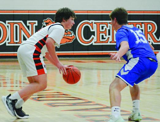 SOPHOMORE COLLIN LYON (left) looks to drive for Hardin-Central in the fourth quarter while guarded by Tri-County junior Carter Fewins. SHAWN RONEY | Staff