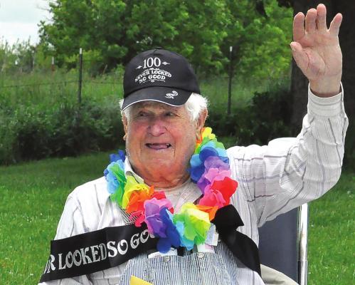 SURPRISED by dozens of drive-by birthday well-wishers, Ted Thomas, 100, gives them a wave. SHAWN RONEY | Staff
