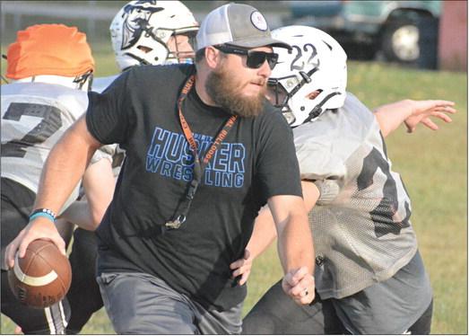 WEARING HIS ballcap, shades and coaching whistle, Norborne Hardin-Central varsity 8-man football coach Andrew Watson rolls out Tuesday on the Hardin-Central practice field to help similuate Braymer/Breckenridge’s offense. SHAWN RONEY | Staff
