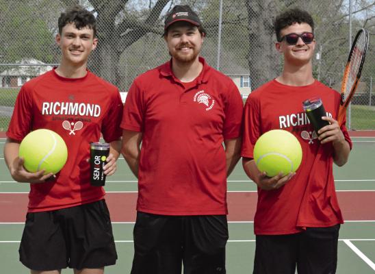 SENIORS BRODY BURNINE (left) and Jazspher Ulleberg (right) display the oversized tennis balls and tumbler cups presented to them on Senior Night as they flank Richmond tennis coach Zachary Baldauf. Tennis coverage continues on page 12. SHAWN RONEY | Staff