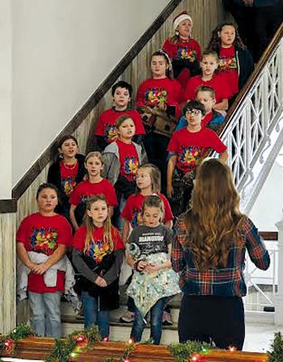 SUNRISE STUDENTS entertain the town of Richmond with songs recently, sparking Christmas spirit not only at the Ray County Courthouse (shown here) but also at the senior center and around the town square. Music teacher Kaelyn Rich guides and instructs the caroling on the chilly morning. BILLY GAINES | Submitted