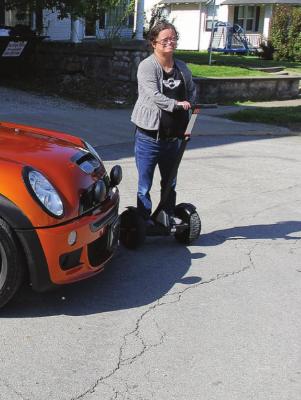 ON A SEGWAY, Hilary Morrissey, Macon, helps direct some of the estimated three dozen participants in the Mini Cooper Rally to parking spots on West Main Street.
