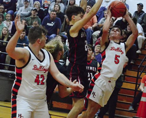 HARDIN-CENTRAL senior Kameron Pugh attempts a leaning jumper while teammate Jesse Doyle signals he’s open Dec. 21 against visiting Braymer. SHAWN RONEY | Staff