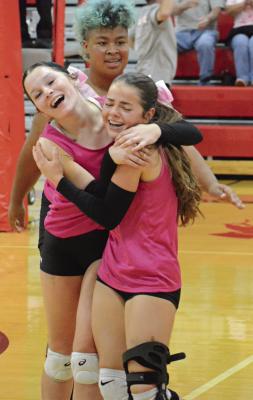 SYDNEE BURNETT (left) and Genevieve Didier embrace after a set victory, with AJ Jones behind them. SHAWN RONEY | Staff