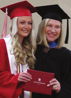 GRADUATION is not typical due to the school year and graduation date changes forced on Missouri school districts by the novel coronavirus, COVID-19. Dice Photography photographer David Dice says the virus cut his business by about 95%. During a mock graduation ceremony, Richmond High School valedictorian Abby Vandiver receives her diploma from her mother, Richmond Board of Education President Penny Vandiver. Both look toward Dice to capture the moment. J.C. VENTIMIGLIA | Staff
