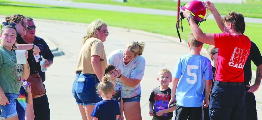 CHILDREN ATTENDEES try on the Richmond Fire Department helmets. SHARON DONAT | Staff
