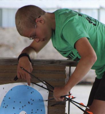 MORGAN REEVES collects his shots from the target after participating in the archery competition.
