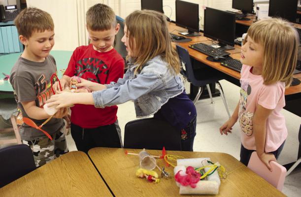 COOPER BURNETT (from left), Chance Wegley, Averionna Lee and Barbara Floyd retrieve their group zip line device to test in Vest’s class. They are seating a doll in place to test the quality of their zip line — that is, whether it will hold her. In this case, the group’s device did indeed work.