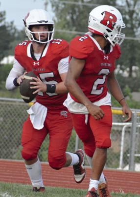 RED TEAM QUARTERBACK Jacob Lieberknecht (left) rolls out with running back Cyrus Jackson in front. Jackson contributed a third-quarter TD run in the Red Team’s one-point loss to the White Team in Richmond’s annual Red and White Game.