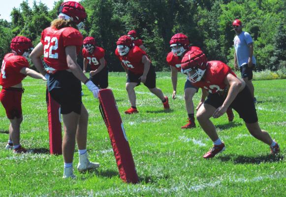 SPORTING HIS shades and ballcap, Richmond varsity football coach Nick Persell watches a group of his Spartans practice the rolling tackle drill Monday on the Richmond practice field. SHAWN RONEY | Staff