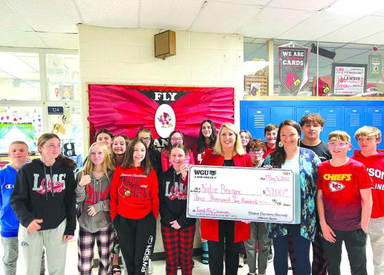 KATIE BERGER, in blue, along with her eighth-grade class, accepts a check from Angie Besendorf, WGU Missouri chancellor. SUBMITTED