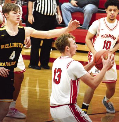 SOPHOMORE CALEB MOYER (center) is pursued by Wellington-Napoleon senior Brody Best as Richmond teammate Gabriel Ramos watches. SHAWN RONEY | Staff
