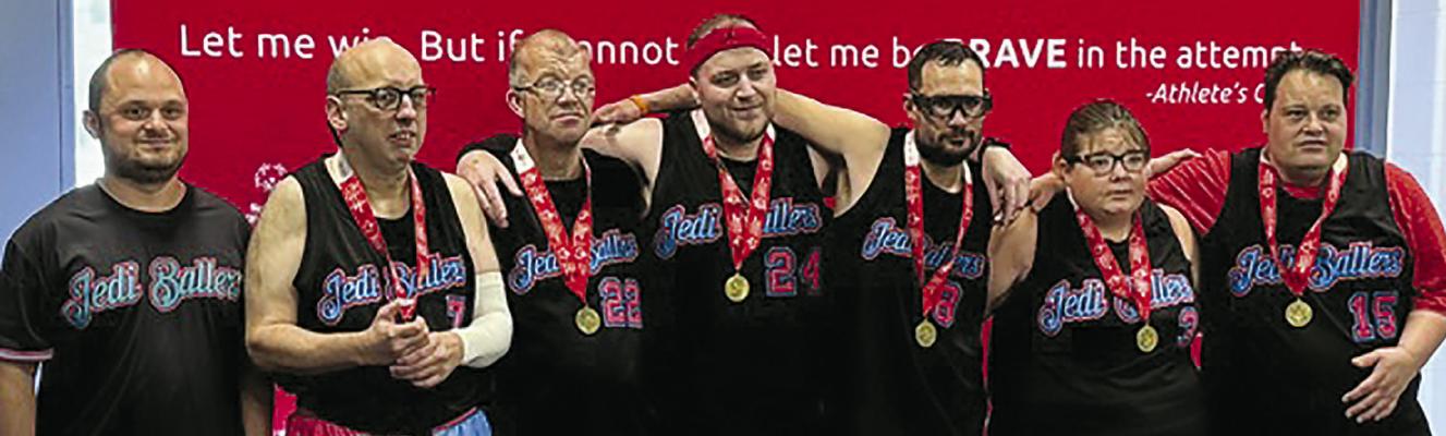 COACH RYAN HERRERA (from left) celebrates with David Lamar, Brian Harrison, Caleb Shockey, Cody Stevens, Hannah Kinard and John Connor after earning a gold medal with 20-4 and 20-6 wins at the Special Olympics basketball tournament in Jefferson City. Submitted