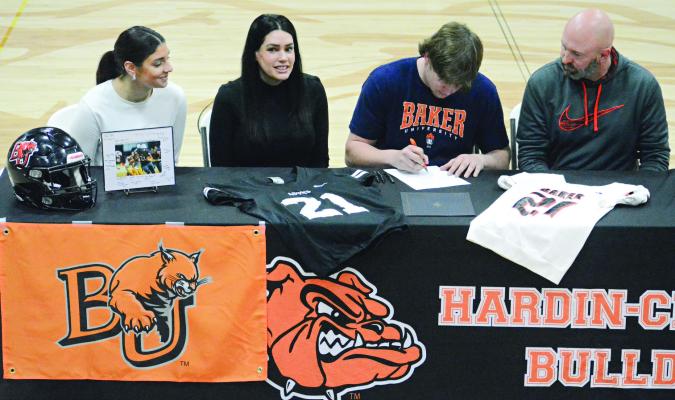 SPORTING HIS Baker University T-shirt, Hardin-Central senior Gage Smith signs his letter of intent to play college football. Also pictured amid the memorabilia are (from left) Mackenzie Smith, Marie Smith and Travis Smith. SHAWN RONEY | Staff