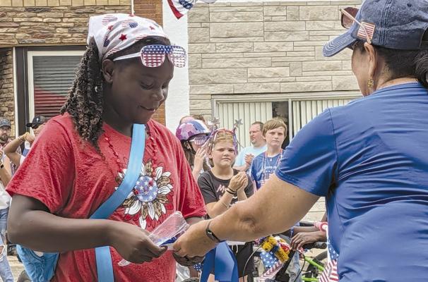 MIRANDA JAMISON | Staff GRACE SISSON-DODSON accepts her award after earning first place in her age division of the decorated bicycle contest.
