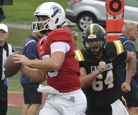 SENIOR JACOB LIEBERKNECHT (left), rolls out, looking to pass during Richmond’s jamboree scrimmage with Cameron. He is expected to help provide team leadership for the Spartans this season. SHAWN RONEY | Staff
