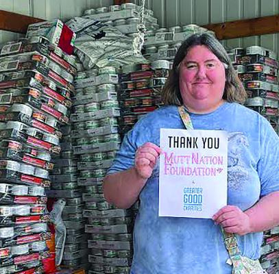 Bark Bargain Thrift Shop Manager Jenifer Dickson accepts the “Muttnations and the Goods” food donations for the pantry. JENIFER DICKSON | Submitted