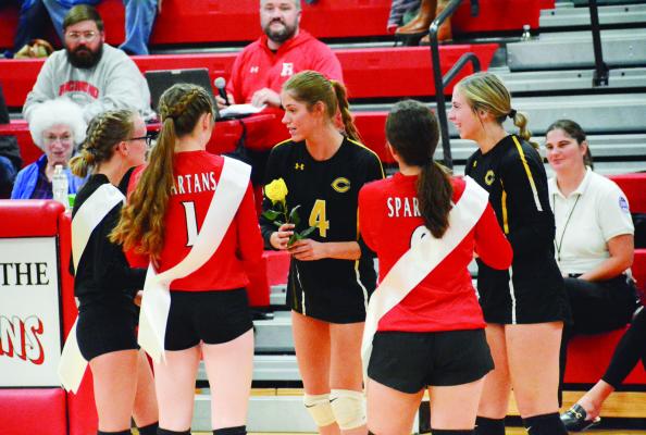 FROM LEFT, with their backs to the camera, Richmond seniors Alli Powell, Kelly Jaggars and Sara Brungardt give a yellow rose apiece Tuesday night to Cameron seniors Claire Wenk, No. 4, and Jessica Kirkendoll on Senior Night at Richmond High School. SHAWN RONEY | Staff