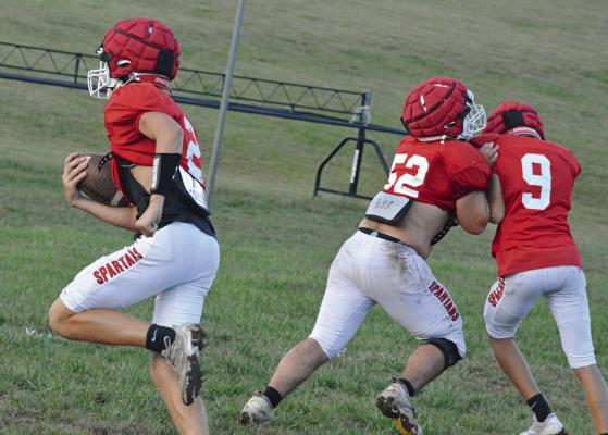 BRYER FARNAN (No. 2) bolts for the end zone as Landon Garrett (No. 52) blocks Mattox McCloud Tuesday on the Richmond practice field. SHAWN RONEY | Staff