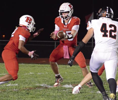 SHORTLY AFTER Richmond’s goal line stand, running back Cyrus Jackson (left) prepares for a handoff from quarterback Jacob Lieberknecht to help the Spartans run out the clock and end Knob Noster’s bid for a perfect season. SHAWN RONEY | Staff