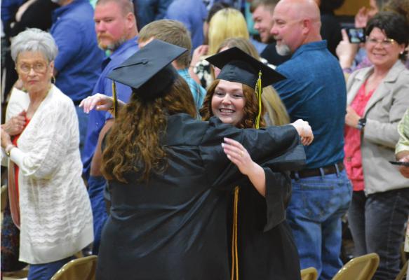 SAVANNAH BARTLEY hugs a classmate during the opening processional. SHAWN RONEY | Staff