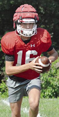 AFTER STUDYING VIDEO with his teammates, Richmond quarterback Jacob Johnson looks to pitch as the Spartans go through running game drills Monday on their practice field. SHAWN RONEY | Staff