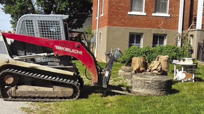 VOLUNTEERS PLACE the newly donated column piece on the Ray County Museum lawn. Submitted