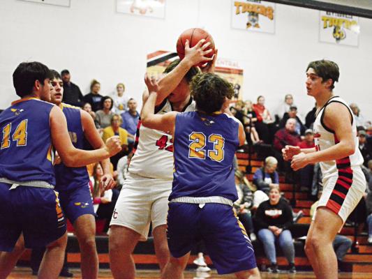 HOLDING THE BALL above his head, Hardin-Central junior Jesse Doyle tries to muscle his way through the Northwestern of Mendon defense Dec. 15 during Hardin-Central’s 53-33 home loss. SHAWN RONEY | Staff