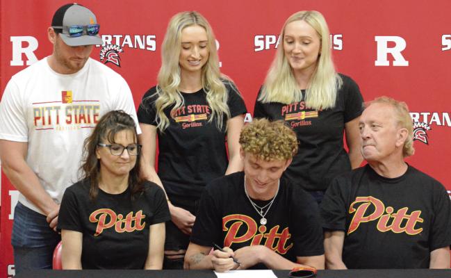 RICHMOND SENIOR Jacob Johnson (front row, center) signs his letter of intent to attend and compete in men’s track at Pittsburg (Kan.) State University as his proud family watches. Also on the front are (from left) parents Stephanie and Kelly Johnson. On the back row are his brother-in-law, Sawyer Junker; sister, Brittany Junker; and sister, Nicole Johnson. SHAWN RONEY | Staff