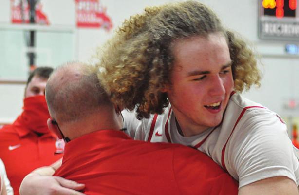 IN VICTORY, coach Kevin Jermain gets a hug from sophomore Jack Gogue. SHAWN RONEY | Staff