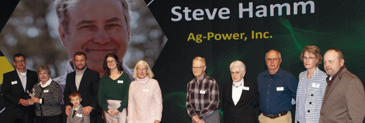 STEVE HAMM’S family accepts his John Deere Honorary Technician of the Year award during a ceremony recognizing technicians across the United States and Canada. Submitted