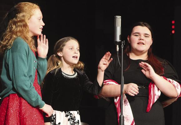 ANNA GARLAND (from left), Paige Quick and Isabella Hensley rehearse a scene during the “It’s a Wonderful Life – Radio Edition” production. SHARON DONAT | Staff