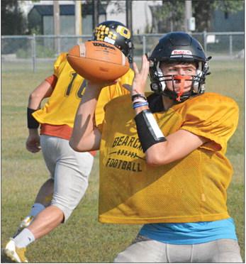 GAGE TEBBE, Orrick’s new quarterback, rears back to throw as Jaxon Miller runs a pass route behind him Monday on the Orrick practice field. SHAWN RONEY | Staff