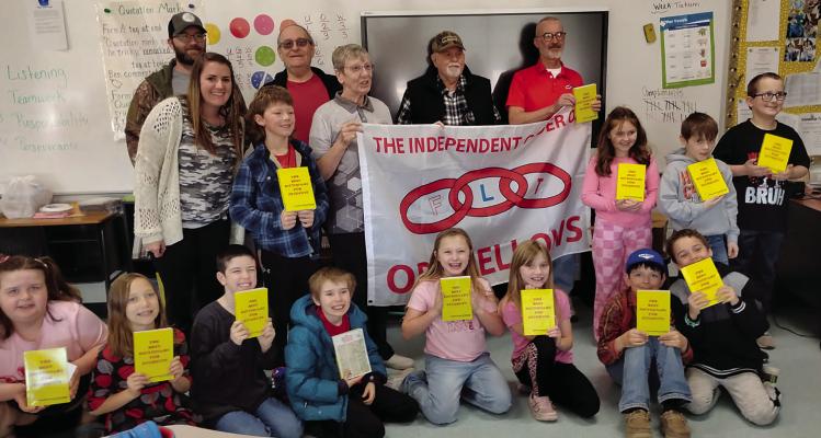 MEMBERS OF THE HIGGINSVILLE Odd Fellows donate dictionaries to third-grade students at Hardin-Central. Submitted