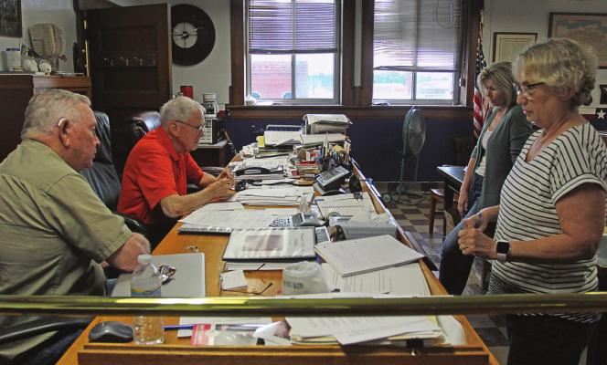 COMMISSIONERS listen to advice from state and national officials. From left are Commissioners Jerry Bishop and Bob King, Treasurer Melissa Holloway and County Clerk Glenda Powell.