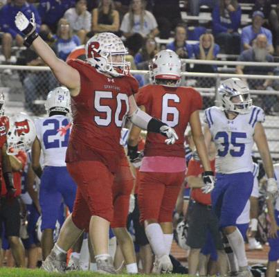JOHN WEBER indicates it’s Richmond’s ball after he and his fellow Spartans make a fourth-down stop during the final quarter of Richmond’s Senior Night win over Holden.