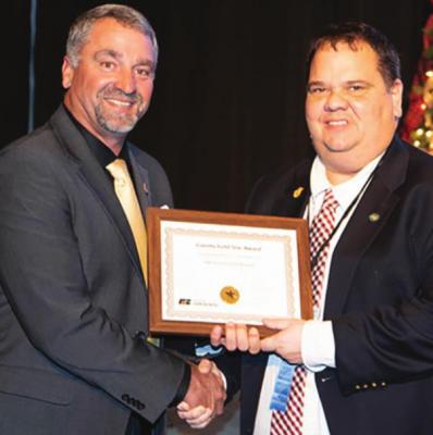 MISSOURI Farm Bureau Board member Jason Kurtz presents a Gold Star Awards program plaque to Joe Robinson.