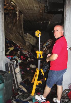 RICHMOND Salvation Army Director Phil Powers shows fire damage makes a shambles of the organization’s new building.