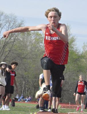 WITH ONLOOKERS nearby, Jacob Johnson extends his right arm as he goes airborne while competing in the boys triple jump at the Bruce Finlayson Invitational April 19 at Carrollton. Johnson wins the event and the long jump. SHAWN RONEY | Staff
