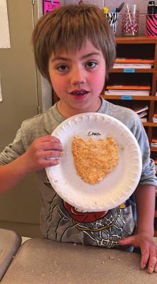 DEAR ELEMENTARY student Chase Racy shows off the particleboard he creates.