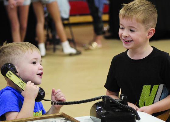 TUCKER AND BECKETT HAMM explore a rotary phone at the Ray County Historical Society and Museum booth during the ForFFA Summer Bash held at Richmond High School. SHARON DONAT | Staff