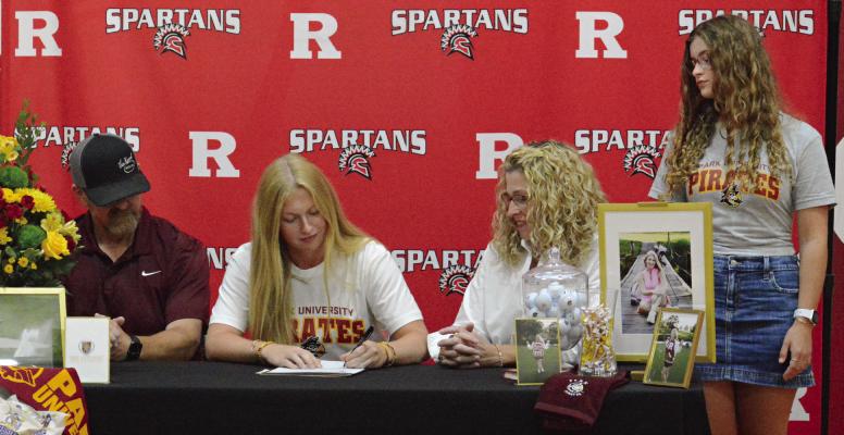 KAROLINE DOOLEY (center) celebrates her signing with Park University. Family members also enjoying the moment are (from left) Bill, Karmen and Isabella Dooley. SHAWN RONEY | Staff
