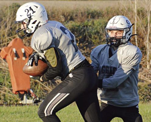 GAGE SMITH (No. 21) takes a handoff from Norborne Hardin-Central quarterback Brody Fifer late in practice Monday at Hardin-Central. SHAWN RONEY | Staff
