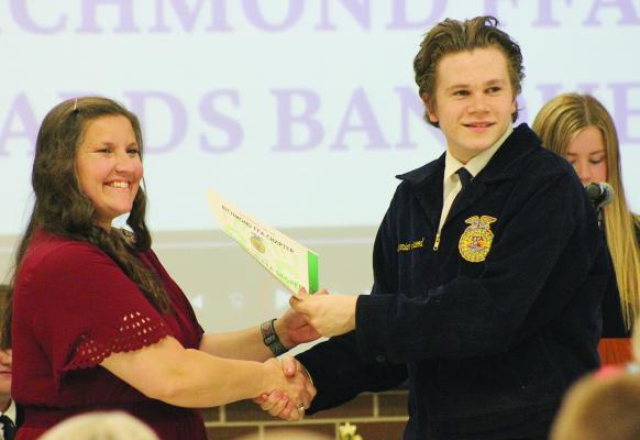 FFA ADVISOR LAURA ALLEN (LEFT) presents an award to high school student Jeremiah Silkwood. SOPHIA BALES | Staff