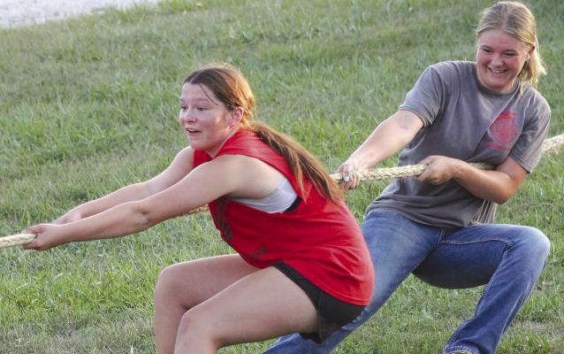 SYNDEE BURNETT (left) and Addison Burk pull with all their might during the tug-o-war event.