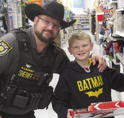 RCSD DEPUTY Brian Lackey (left) and Lelyn Hembree check out the nerf guns while participating in the Shop with a Sheriff event. MIRANDA JAMISON | Staff