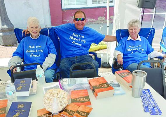 MARTHA GRUBBS (left), Drew Crowley and Zina Bush take their turn while volunteering for the Brothers and Sisters in Christ booth. Volunteers came from several congregations. DAVID DONALDSON | Staff